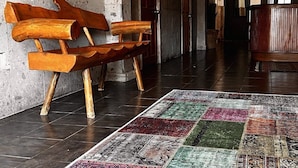 Un banco de madera, un mapa mundial y un cartel que dice 'BAJA REAL Hostel Boutique' en un pasillo.