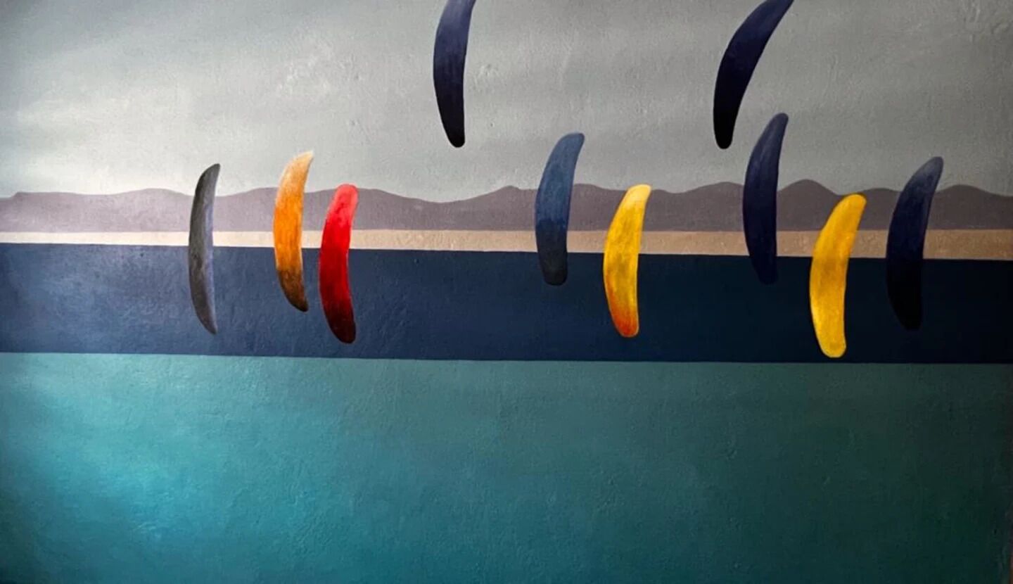 A mural with abstract shapes and a landscape background.