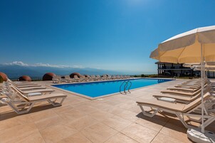 Una piscina al aire libre de temporada, sombrillas