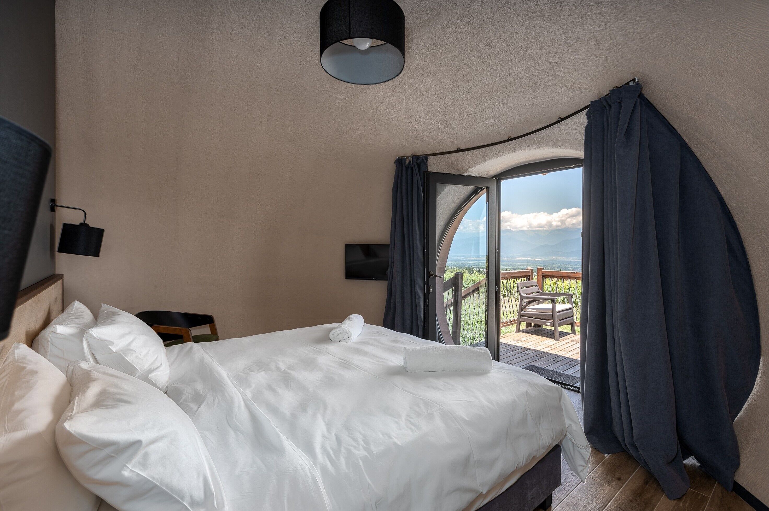 Une chambre à coucher avec un lit, une télévision et une vue sur l’extérieur.