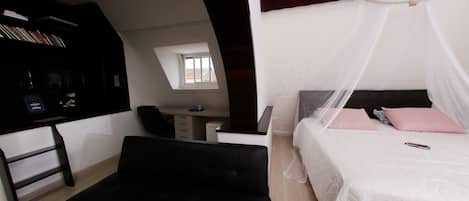 Un dormitorio con cama, escritorio y estantería.
