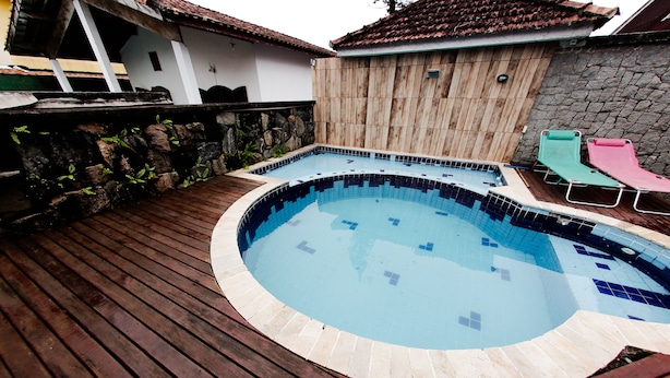 A circular swimming pool with a wooden deck surrounding it. - Castelinho Solemar - Hot Spa (Praia Grande)