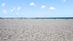 A wide sandy beach with a clear sky and a few clouds. - Mission Paradise - Spa, Pet Friendly, Steps to Sand & W/D! (Mission Beach)