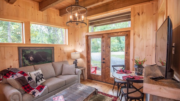 A cozy cabin interior with a sofa, coffee table, and dining area.