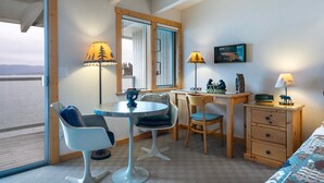 A cozy room with a desk, two chairs, a small table, a bed, and a nightstand. - Flathead Lake Waterfront Studio! (Bigfork)