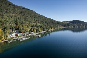 Una propietat a la vora d'un llac amb embarcacions amarrades, un port esportiu i un turó cobert de bosc.