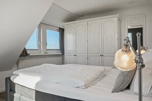 Un dormitorio con cama, ventana y armario.