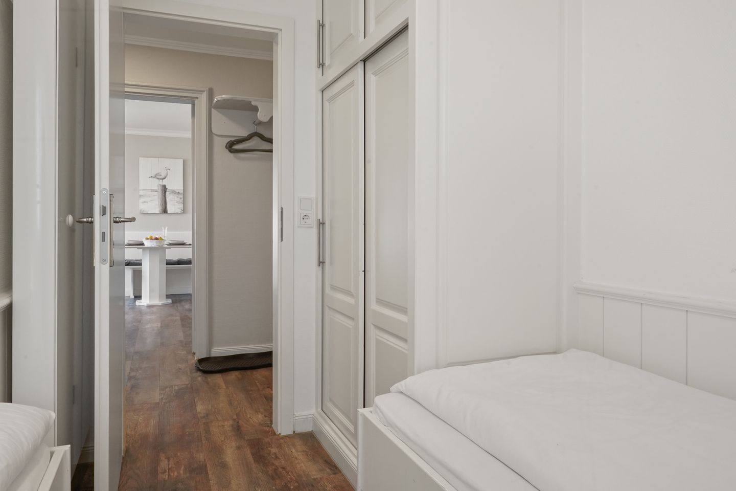 A bedroom with a bed, a wardrobe, and a door leading to a bathroom.