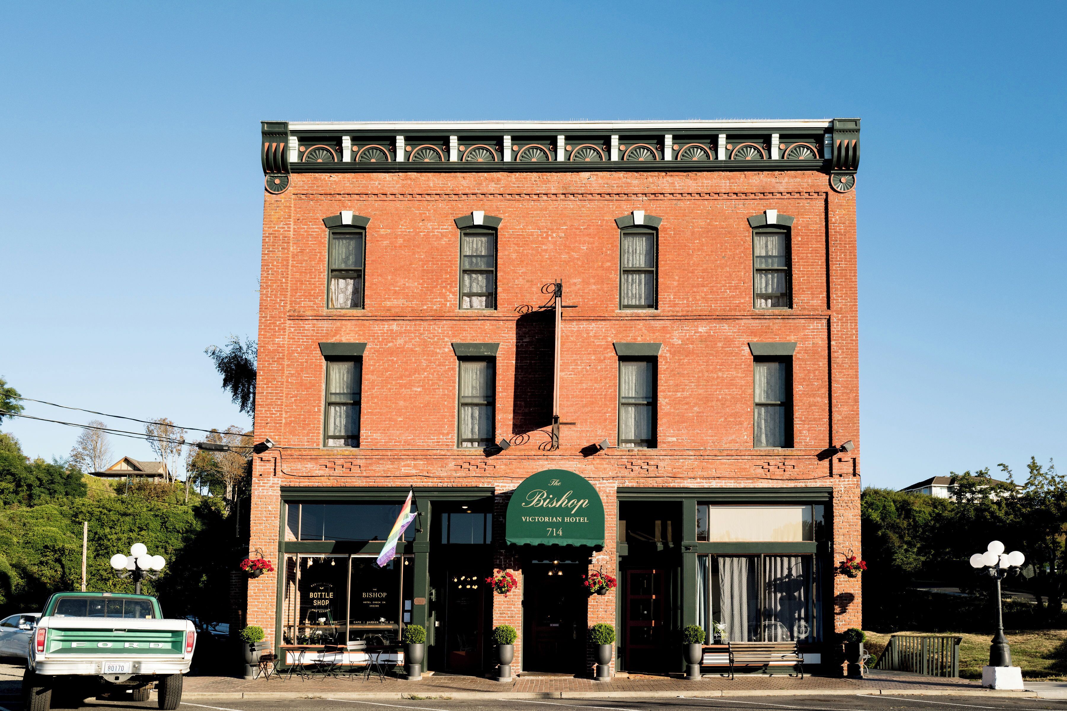 A Victorian-style brick building with a green awning labeled "The Bishop Victorian Hotel 714."