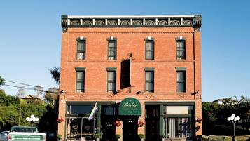 A Victorian-style brick building with a green awning labeled "The Bishop Victorian Hotel 714."