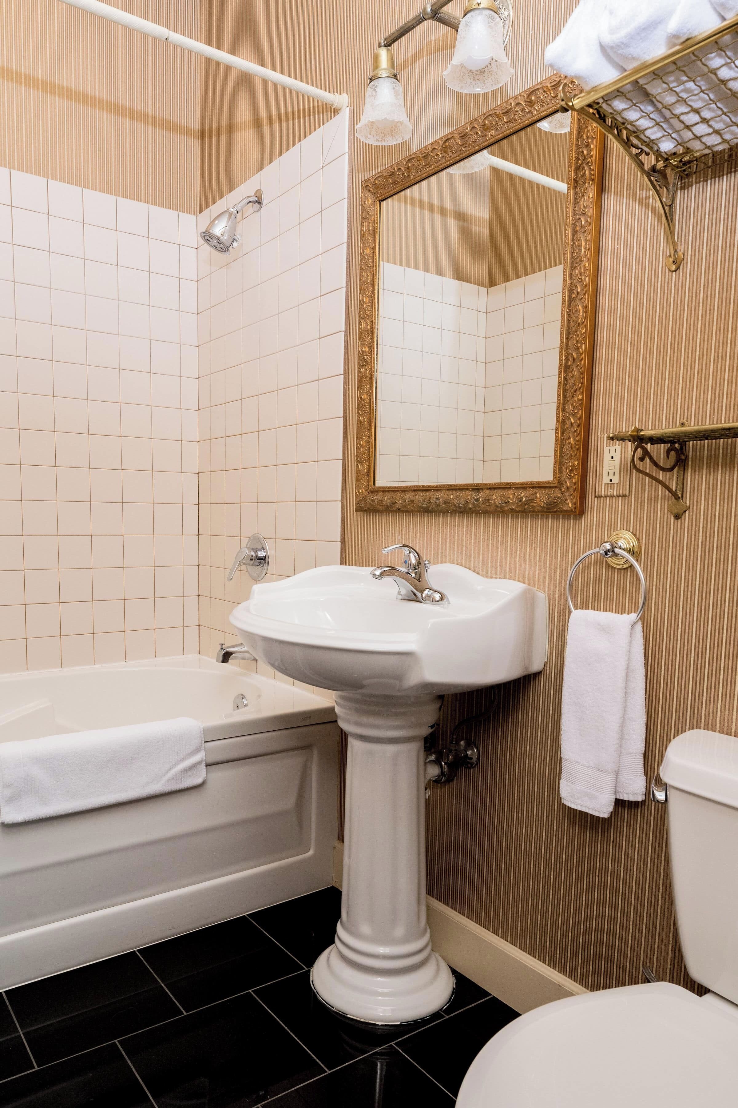 Un baño con bañera, lavabo e inodoro.