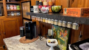Una encimera de cocina con una cafetera, un especiero y un adorno.