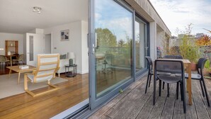 Un espacio habitable moderno con un amplio ventanal corredero que da a un patio exterior.