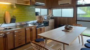 Una cocina moderna con armarios de madera, salpicadero verde y una isla central.