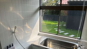 Un baño con ventana, ducha y lavabo.