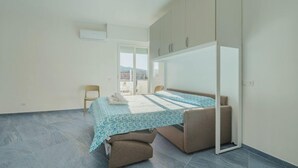 A modern bedroom with a bed, a chair, and a wardrobe.