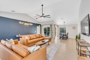 Relax in this spacious living room with a large sofa, coffee table, and dining area.