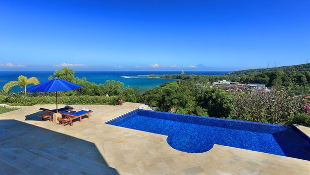 A pool with a view of the ocean and hills. - Villa Kipas Retreat (Senggigi)