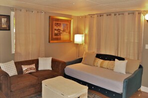 A cozy room with a bed, a sofa, and a small table.