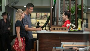 Un comptoir d’accueil avec une pancarte indiquant « RÉCEPTION », et une femme en uniforme rouge derrière.