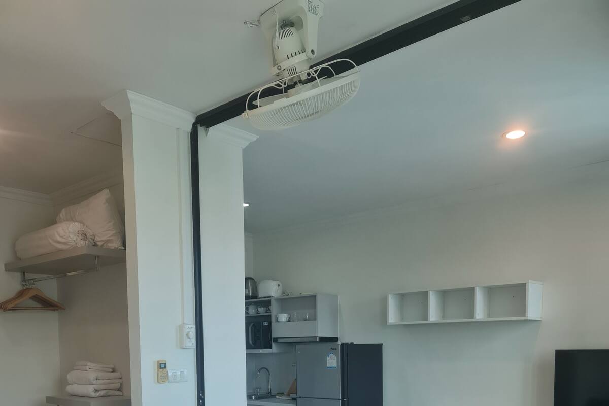 Una habitación de hotel moderna con cama, escritorio, kitchenette y televisión.