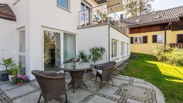 Eine Terrasse mit Korbmöbeln und Blumentöpfen.