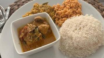 Un plato con arroz blanco, un guiso de curry y dos acompañamientos.