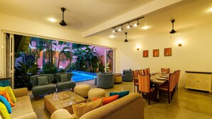 Amplia sala de estar con vista a la piscina, asientos cómodos y comedor.