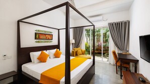 Una cama con dosel con una colcha blanca y naranja, un cabecero de madera y una mesita de noche con una silla a un lado.