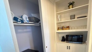 A compact kitchen with white cabinets, a microwave, and a small refrigerator. - Ocean View Studio Near LA Stadium & LAX | Balcony (Manhattan Beach)