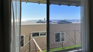 A balcony with a view of the ocean and a building across the street. - Ocean View Studio Near LA Stadium & LAX | Balcony (Manhattan Beach)