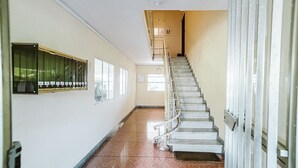 A hallway with a staircase, a row of lockers on the left, and a door at the end. - Appartamento Sauro: A cozy apartment situated a few minutes from the town center, with Free WI-FI. (Rapallo)