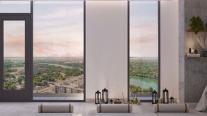 A modern room with large windows, a view of a cityscape, and a serene interior design. - Luxury 1BR +Views+Rooftop Pool +Walk To Rainey St. (Austin)
