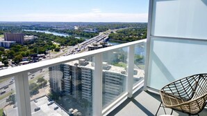 A balcony with a view of a cityscape, including a river and buildings. - Luxury 1BR +Views+Rooftop Pool +Walk To Rainey St. (Austin)
