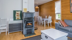Un salon chaleureux avec une cheminée, un coin repas et un canapé.