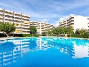 A swimming pool surrounded by multi-story residential buildings with balconies.