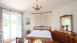Ein Schlafzimmer mit Bett, Kommode, Spiegel und einer Chandelier.