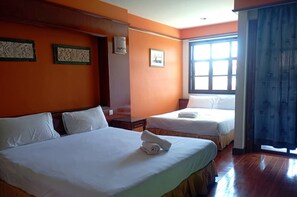 Una habitación de hotel con dos camas, un ventanal con cortinas y una pared con paneles decorativos.