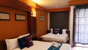 A hotel room with two beds, each with white bedding and pillows featuring the hotel’s logo. The room has wooden paneling on the walls and a large window with curtains. - Alpine LXPD Premium Water Chalet (Port Dickson)