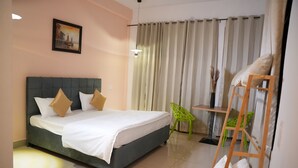 Um quarto com cama, cadeira, escada e cortina.