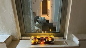 Een vensterbank met een decoratieve pot met lichtjes en versieringen.