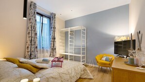 A bedroom with a bed, bedside tables, a desk, a chair, a TV, and a shelving unit. - Apartment 'Soleluna' with Wi-Fi and Air Conditioning (Vado Ligure)