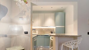 A compact kitchen with a microwave, sink, and a small bar area. - Apartment 'Soleluna' with Wi-Fi and Air Conditioning (Vado Ligure)