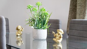 A glass-top table with a potted plant and two golden figurines. - Apartment 'Centro Jerezano 2' with Wi-Fi and Air Conditioning (JEREZ DE LA FRONTERA)