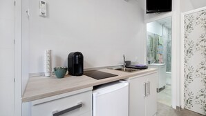 A modern kitchen with a built-in dishwasher, a coffee maker, and a flat-screen TV mounted above the sink. - Apartment 'Centro Jerezano 2' with Wi-Fi and Air Conditioning (JEREZ DE LA FRONTERA)