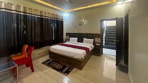 Une chambre à coucher moderne avec un lit, une chaise, une table de chevet et un ventilateur de plafond.