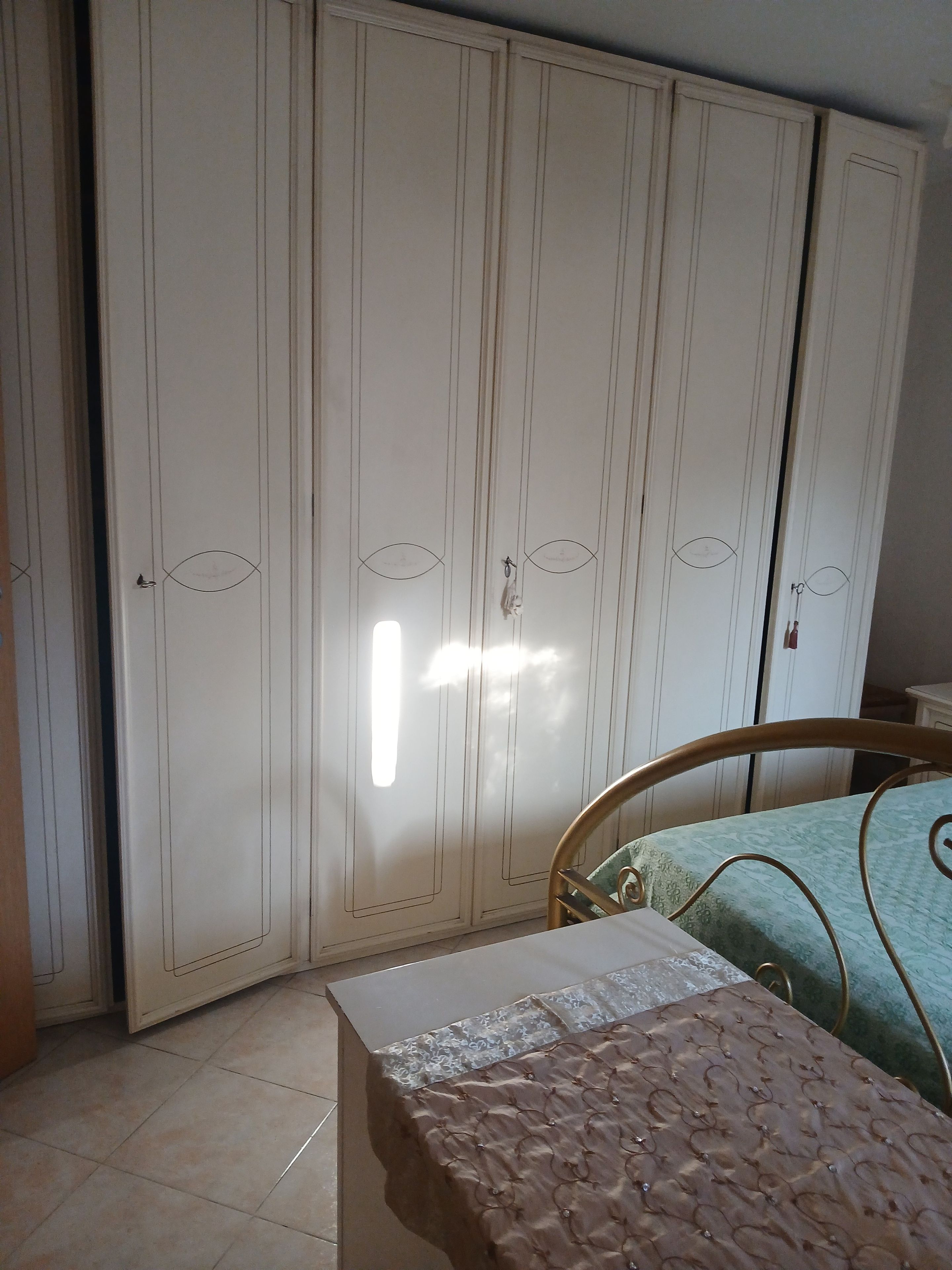 Ein Schlafzimmer mit einem Bett, einem Kleiderschrank und einem Nachttisch.