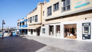 A street with shops, including a visible ATM.