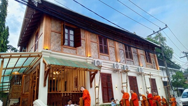 A traditional building with a covered entrance and a series of windows.