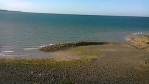 A coastal landscape with a rocky shoreline, calm sea, and clear sky. - Holiday Home 'Ville Daniel' with Private Terrace, Private Garden and Wi-Fi (PORDIC)